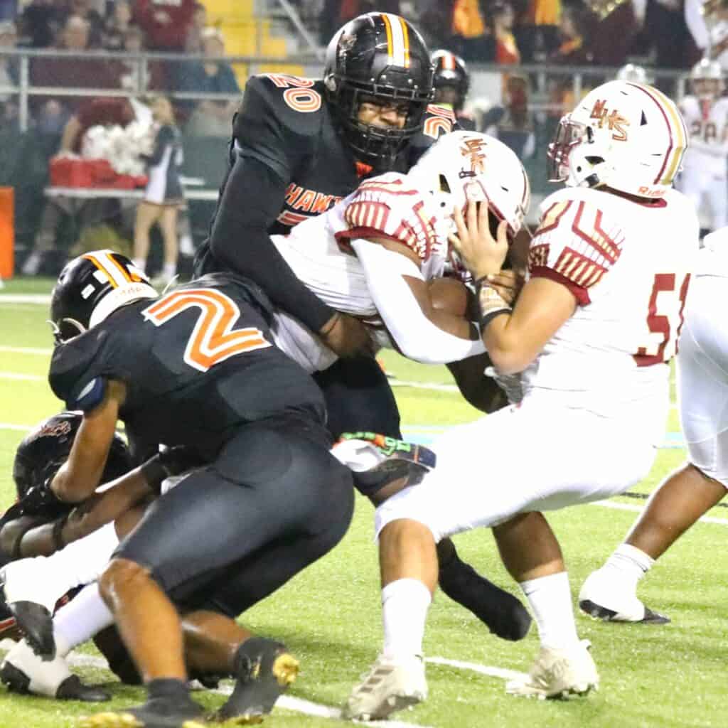 Hawthorne's Demtri Perry (20) and and Darian Smith-Williams (2) on tackle against Northview on Saturday.
