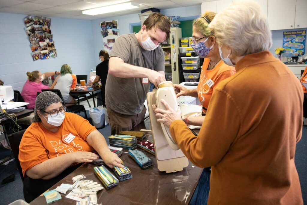 James Spaulding, center, helps fix a sewing machine.