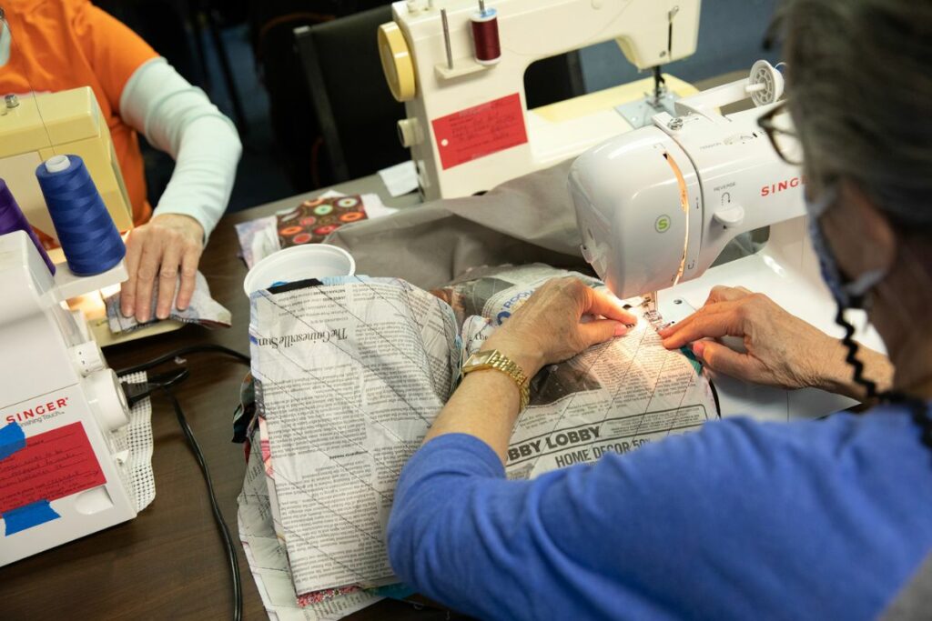 Marité Haynes quilts together a square. The newspaper, which was employed as a guide to make the square, will eventually be removed.