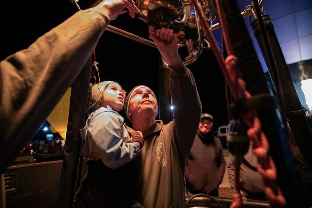 Pilot Henry Rosenbaum shows Broward Roberts, 5, how to ignite his balloon's propane tank. Broward's parents brought he and his younger brother, Brooks Roberts, 3, from Ocala to see the festival