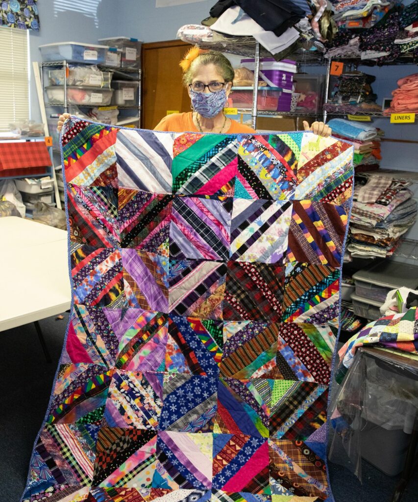Radha Selvester, organizer of the quilt-a-thon, displays a finished blanket.