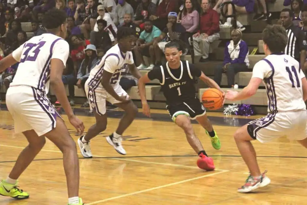 Santa Fe's Makhi Lewis drives between Gainesville defenders on Thursday.