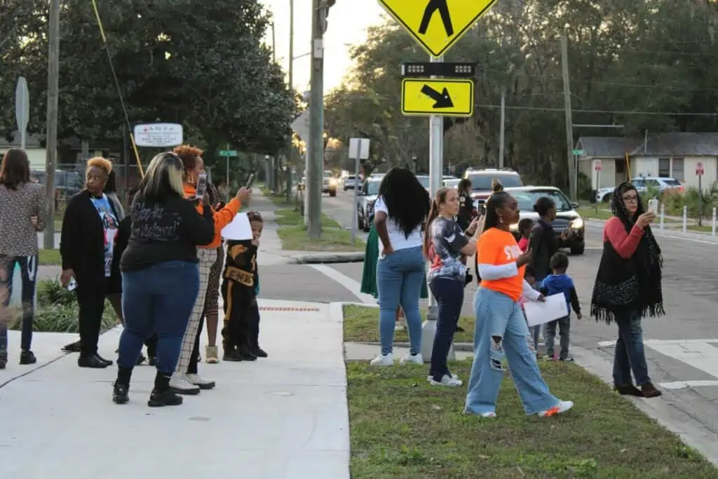 Spectators watch the GPD vehicle procession that kicked off the Night of Compassion event on Friday.