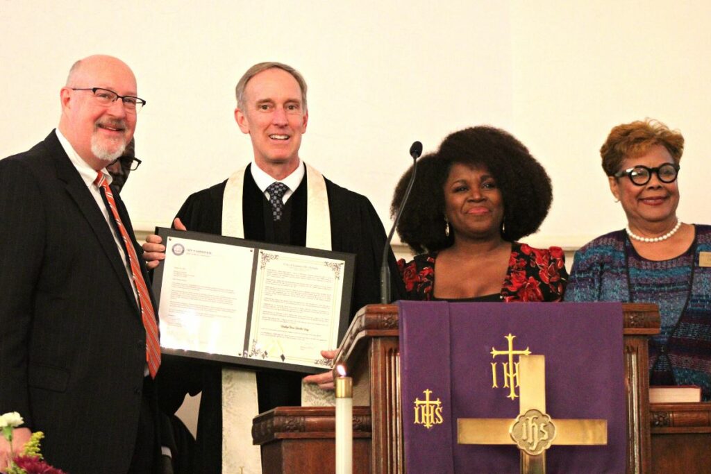 Gainesville Mayor Harvey Ward (left) and city commissioners Desmond Duncan-Walker (second from right) and Cynthia Chestnut (right) present Bishop Tom Berlin a plaque on Sunday.