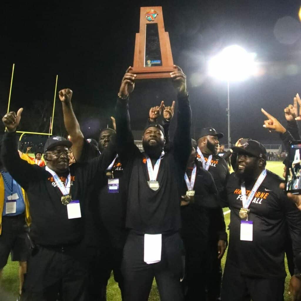 Hawthorne coach Cornelius Ingram (holding trophy) led the Hornets to their first football state title in December.