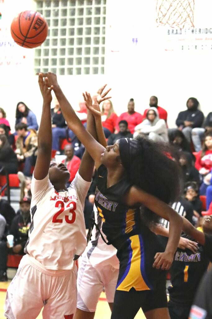 Newberry's Natreana Akanni (5) blocks Williston's Acacia Haynes' (23) shot on Friday.