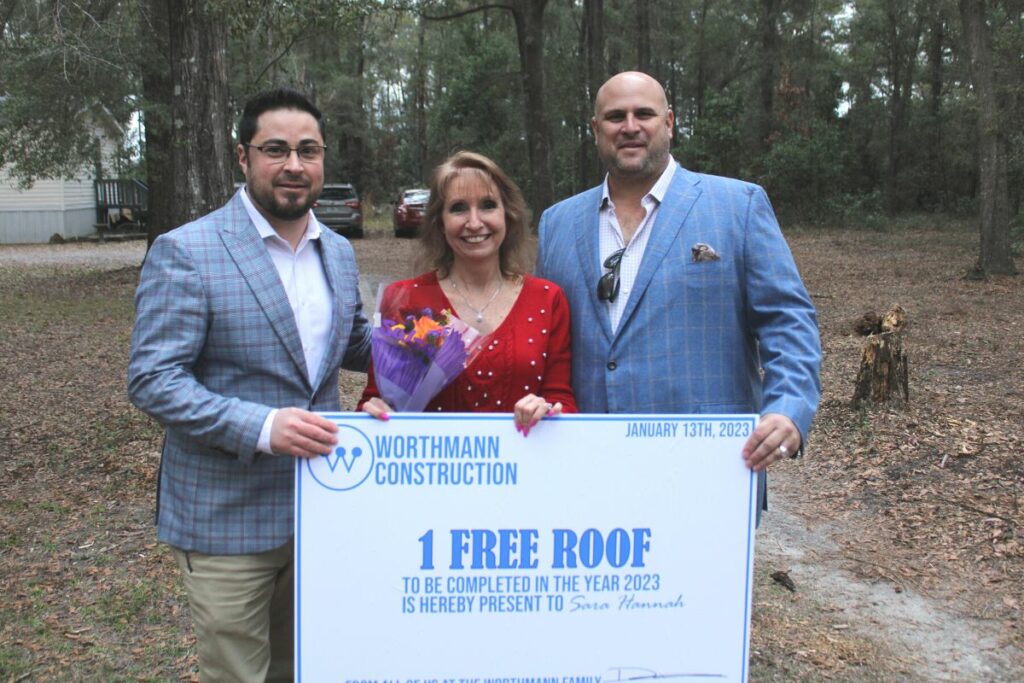 Worthmann free roof giveaway winner Sara Hannah (center) with Worthmann General Manger Eli Ott (left) and owner Drew Worthmann (right) on Friday.