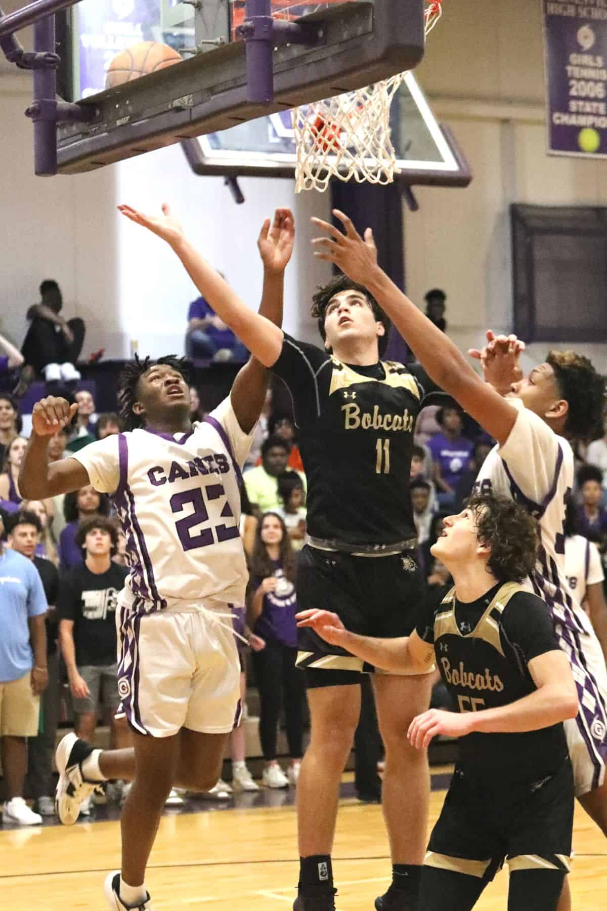 Gainesville's Jordan Bodie (23) and Josh Hayes (33) go for a rebound against Buchholz's Nate Muchnick (11) late in the fourth quarter in the District 6A-2 championship game on Friday.