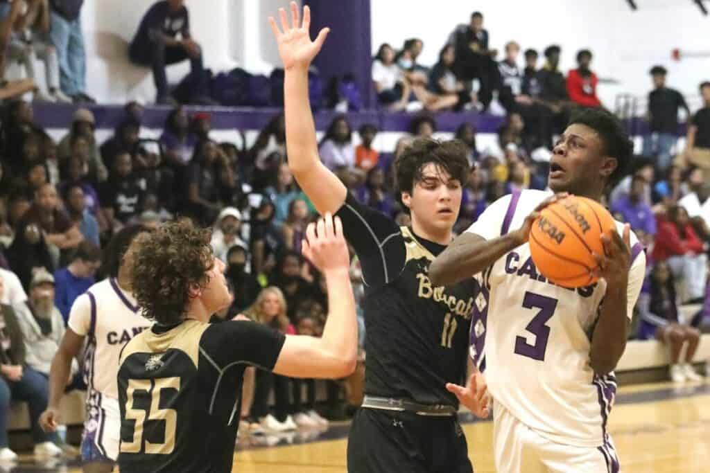 Gainesville's Theo Stephens ties the game at 48 with a shot against Buchholz's Nate Muchnick (11) and Ryan Webster (55) in the District 6A-2 championship game on Friday.