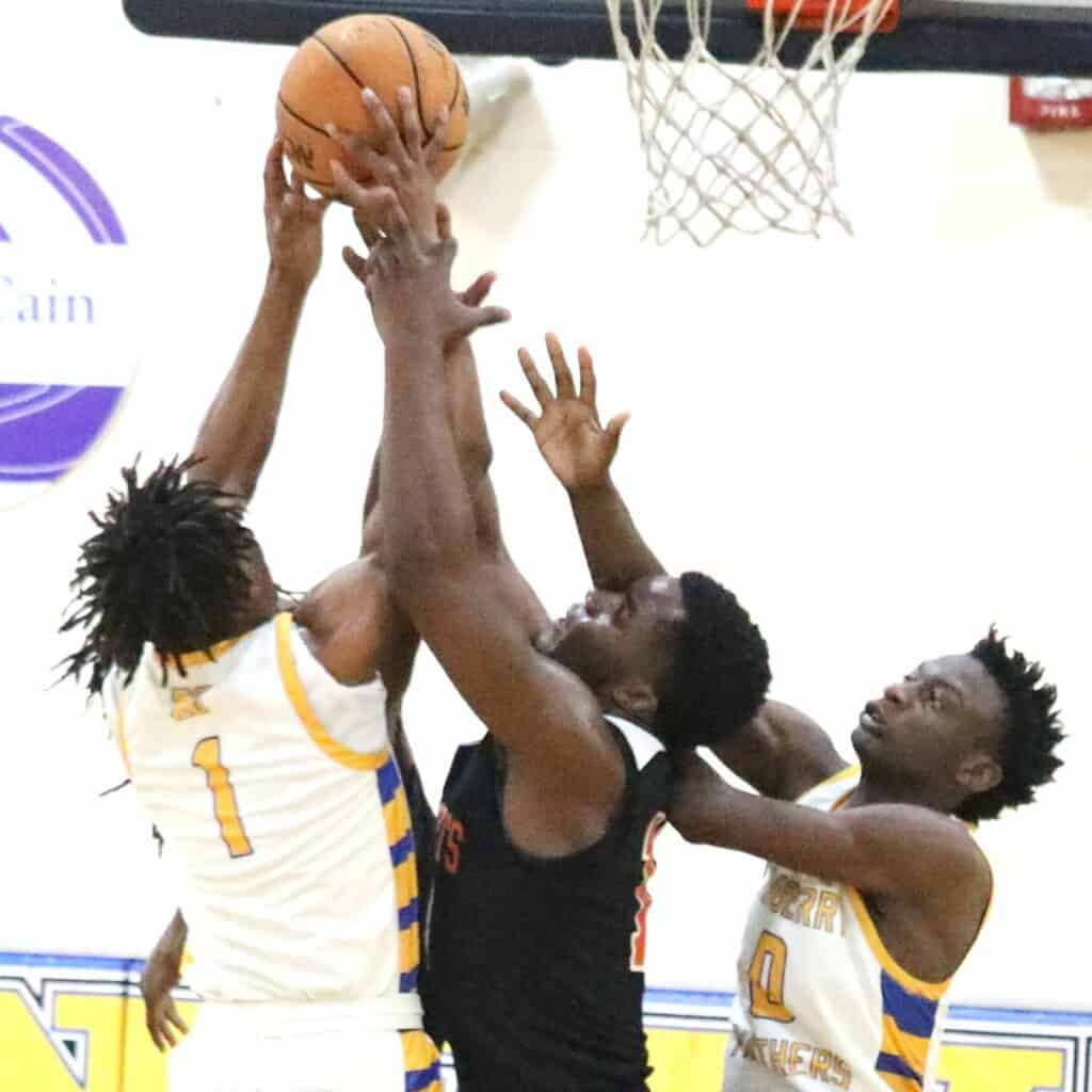 Newberry's Michael Moore (1) and Ray White (0) battle with Hawthorne's Tyler Jefferson for a rebound in the District 1A-6 championship game on Friday.
