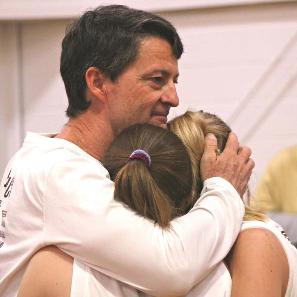 Oak Hall head coach Eric Ringdahl hugs players following his final game with the Eagles on Thursday after 31 years.