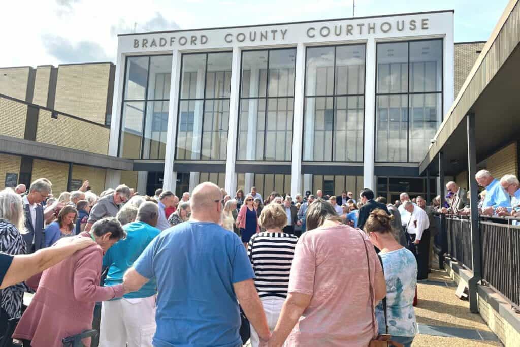 Representatives of the suing churches pray outside the Bradford County Courthouse following the arguments.
