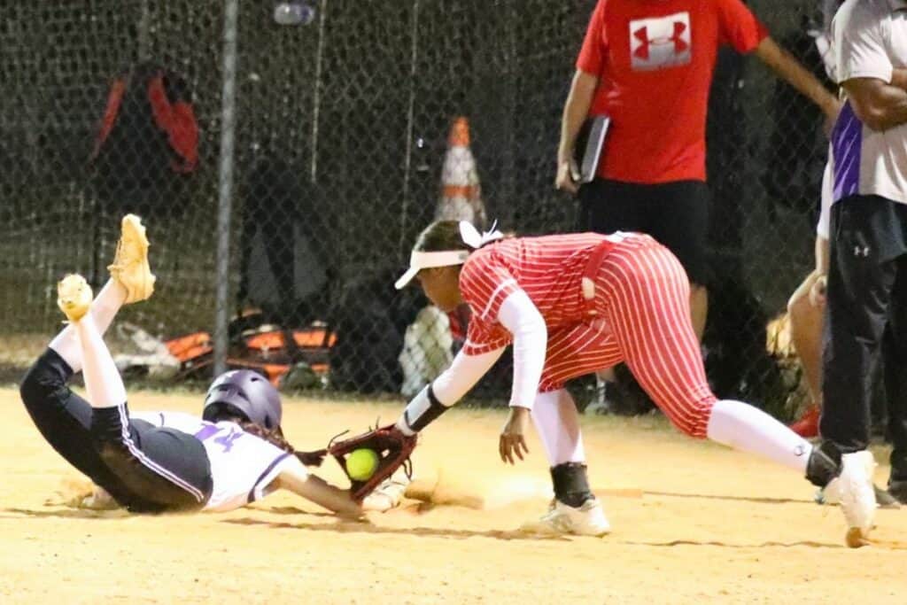 Williston's Nevaeh Hayes tags Gainesville's Samantha Walsh out at first base in the bottom of the third inning on Monday.