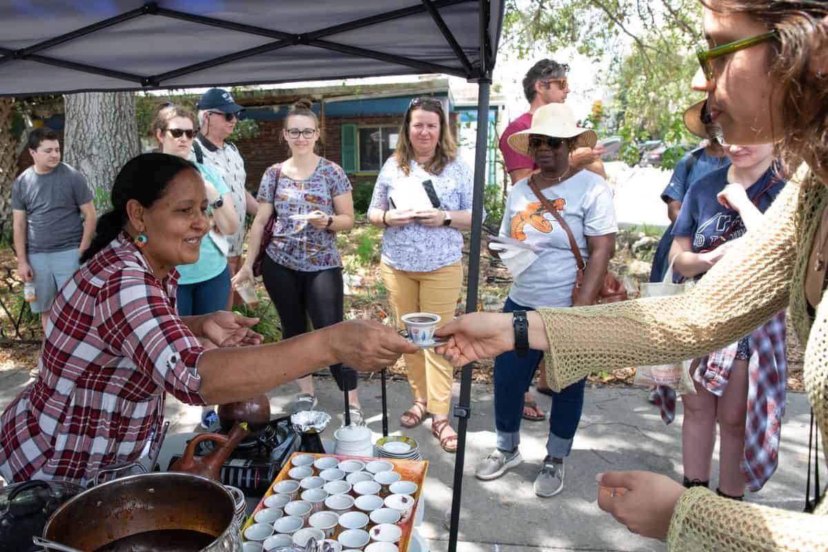 A festival vendor hands out freshly Ethiopian coffee she brewed.
