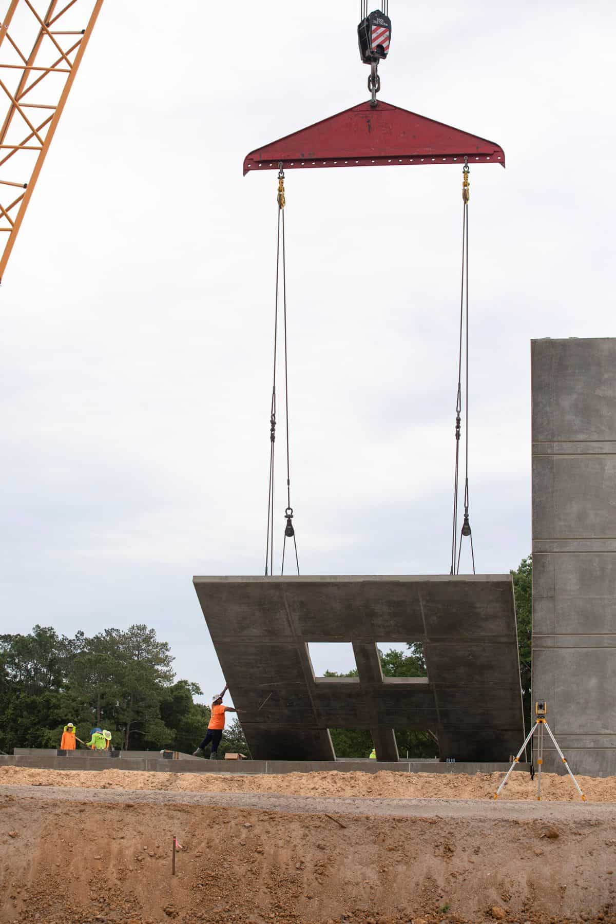 Construction workers raise the second Westwood Middle School wall section into place.