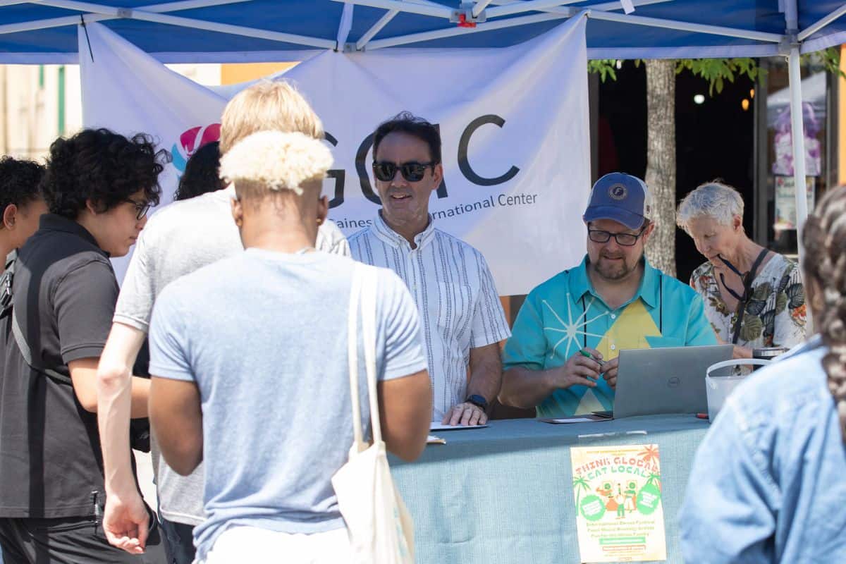 GGIC board member Jeremi Snook, in striped shirt, and GGIC president and CEO Lauren Poe, in hat, hand out food festival passports to registered patrons.