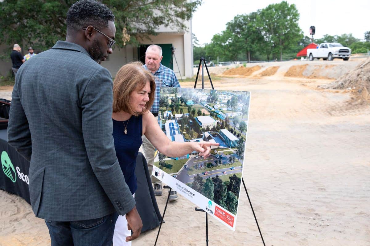 Project architect Chad Jones, left, and Karen McCann, a former guidance counselor at Westwood Middle School, examine a rendering of the finished school.