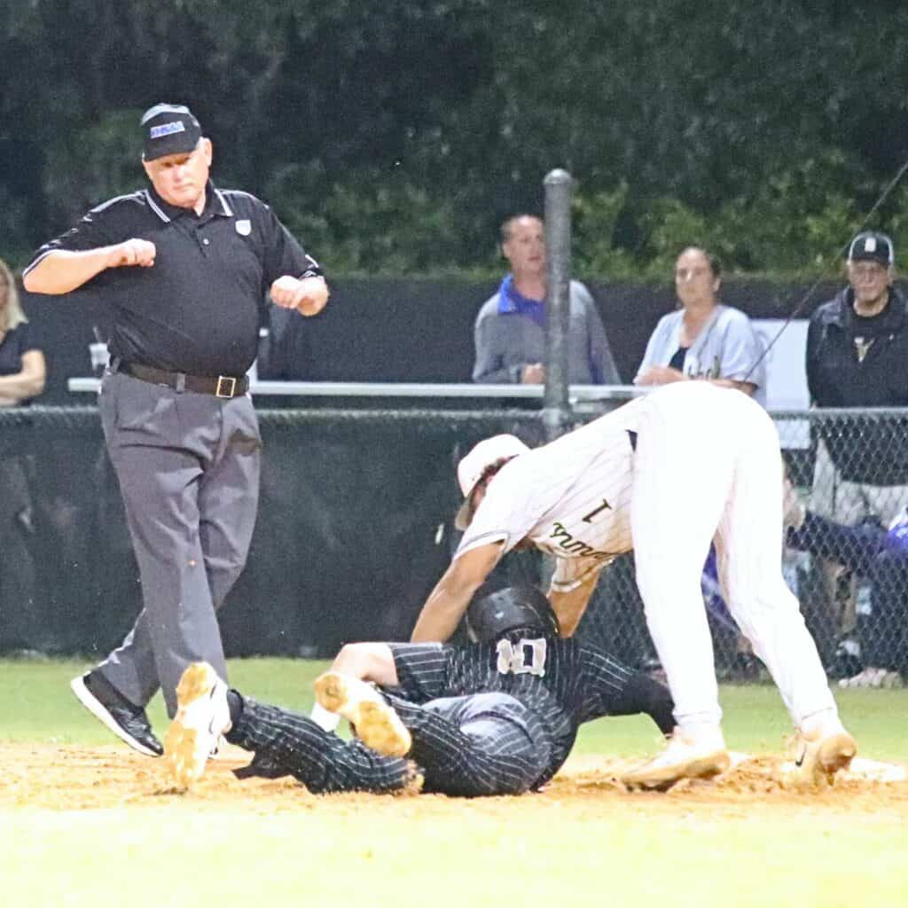 Buchholz's Austin Cardozo (10) dives safely back to first base in the bottom of the third inning against Gulf Breeze on Wednesday.