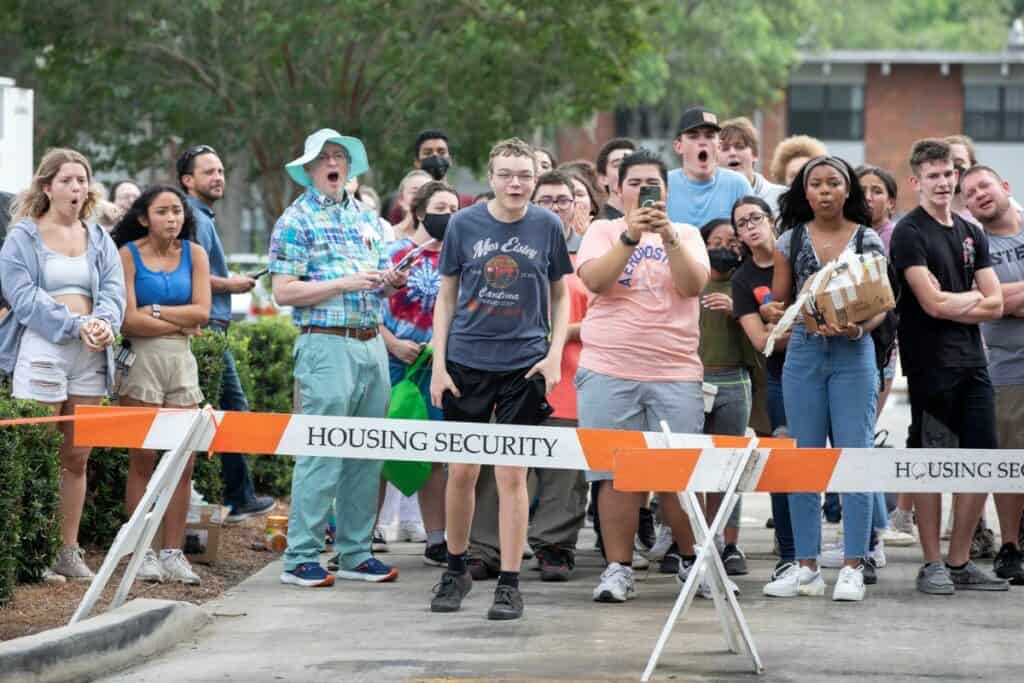 Gainesville High School physics teacher Keith Watts, in plaid, and his students react to the hideous thud that sounded when a large rubber ball containing an egg smacked into the pavement.