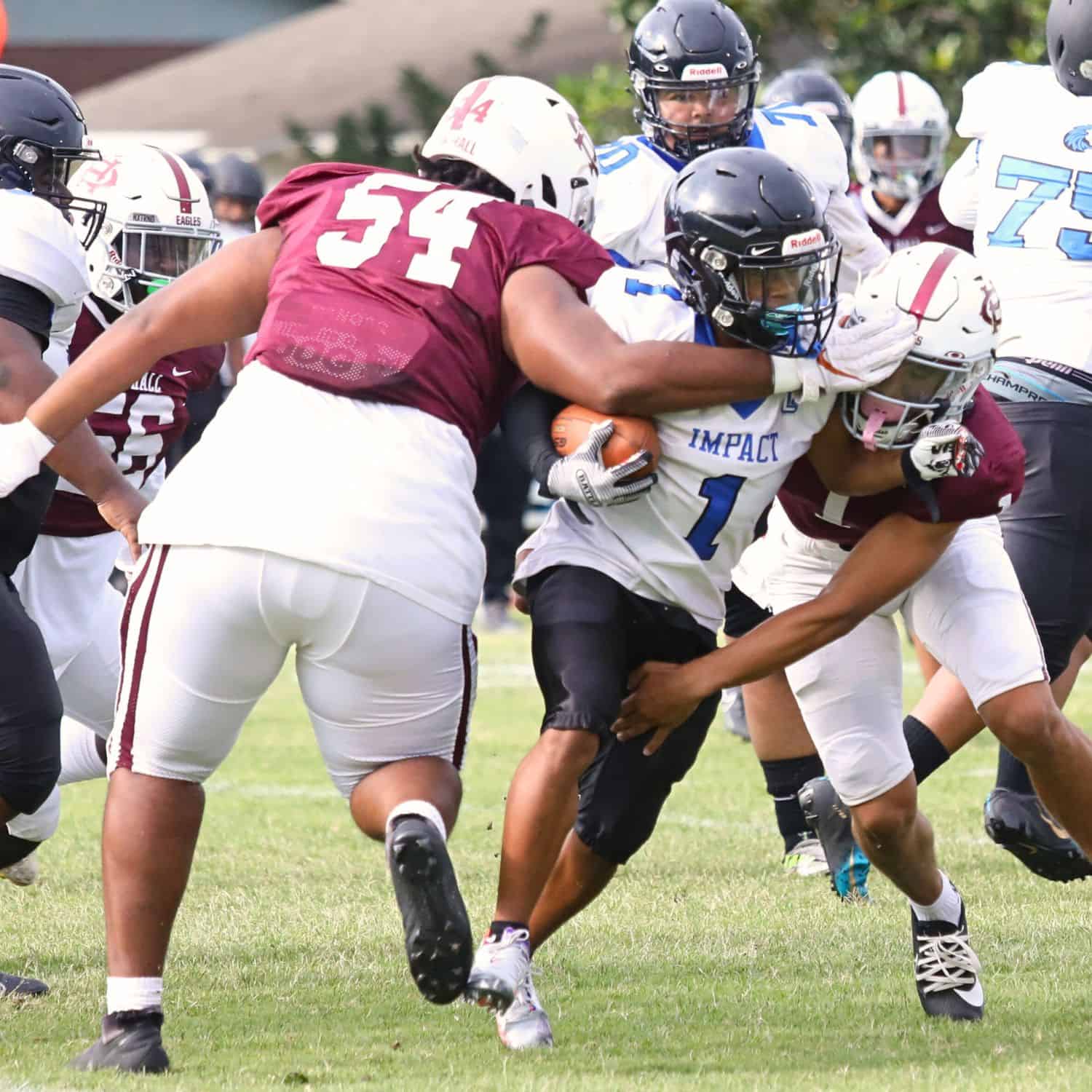 Oak Hall's Christopher Davis (54) and Dakota Brower (1) combine for a first quarter tackle against Impact Christian on Thursday. Oak Hall's Christopher Davis (54) and Dakota Brower (1)