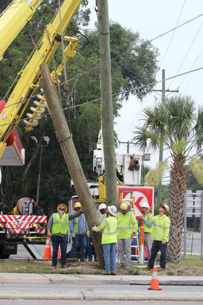 GRU crews lift a new utility pole into position on Wednesday.