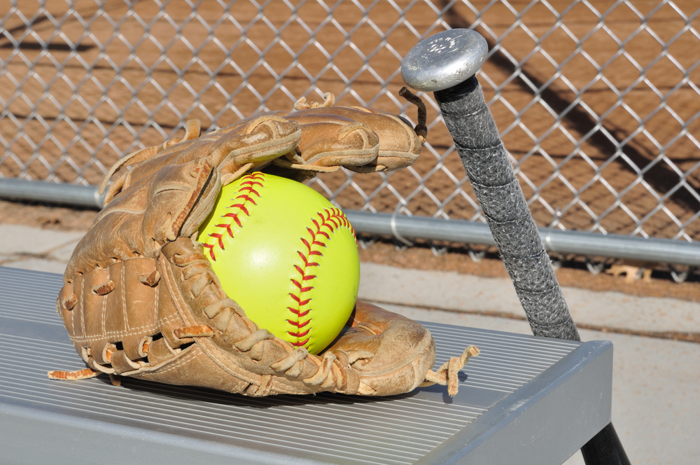 Softball, glove and bat on bench