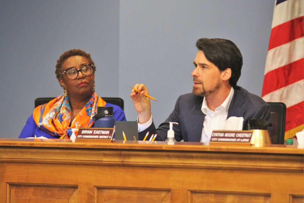 Bryan Eastman speaks at a City Commission meeting as Cynthia Curry looks on