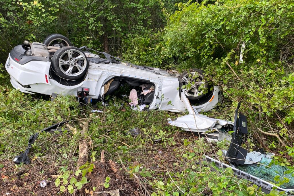 Emergency responders extricated a driver whose car hit a pole and overturned into the woods at the Hawthorne Road and SE 43rd Street intersection Sunday morning.
