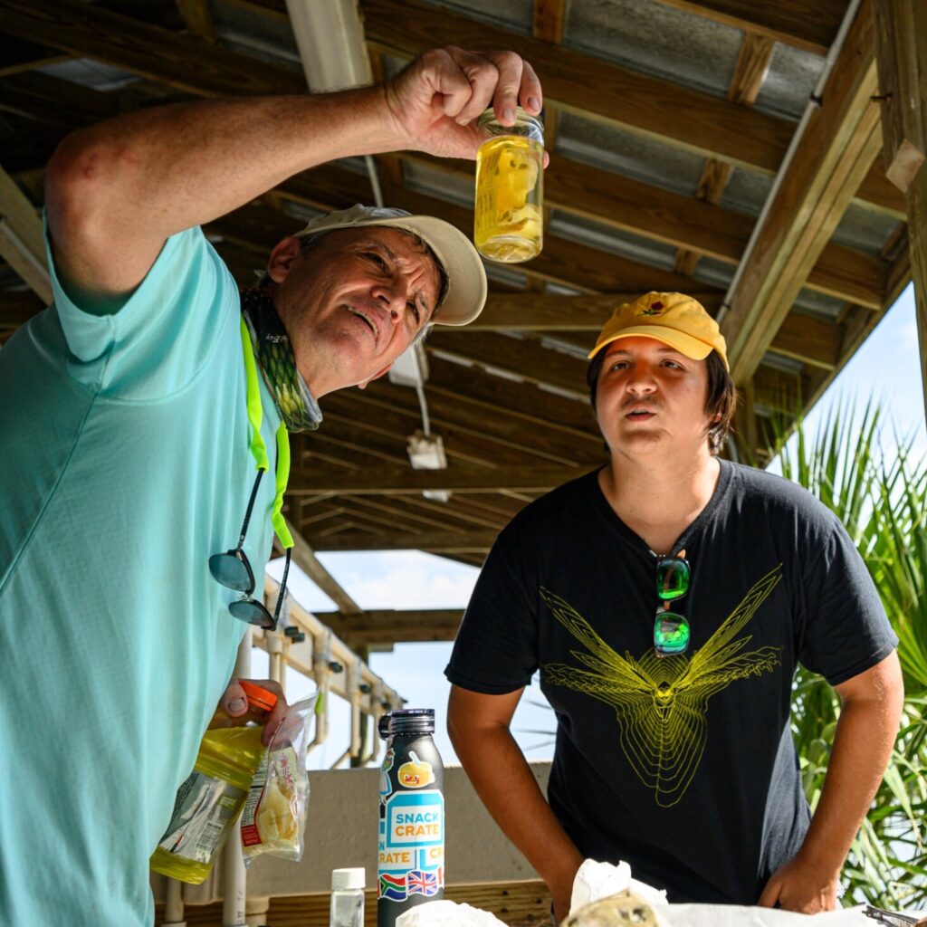 Gavin Naylor (left) views a specimen with a student, Brandon Navarro (right).