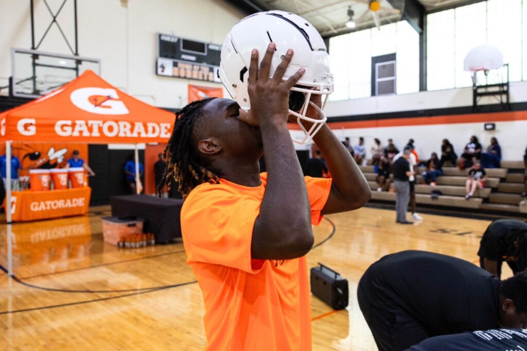 A Hawthorne football player tries on one of the new helmets given to the program from Gatorade and the Jacksonville Jaguars.