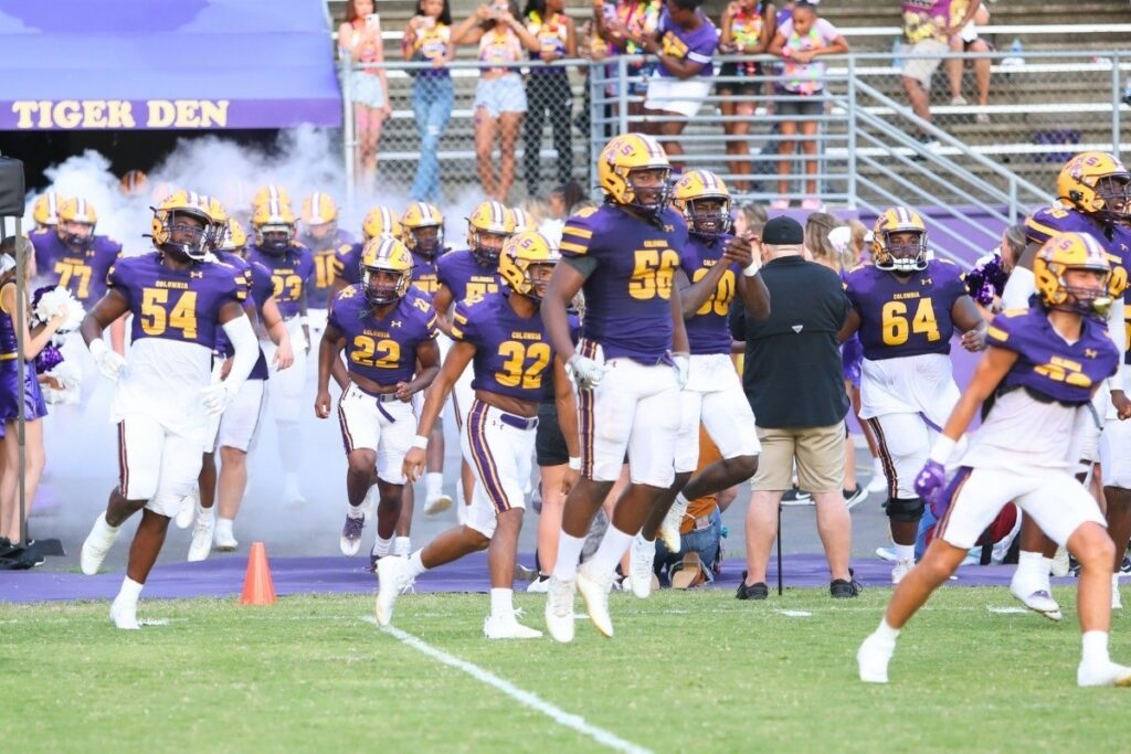 The Columbia football team runs onto the field in Friday's season opener.