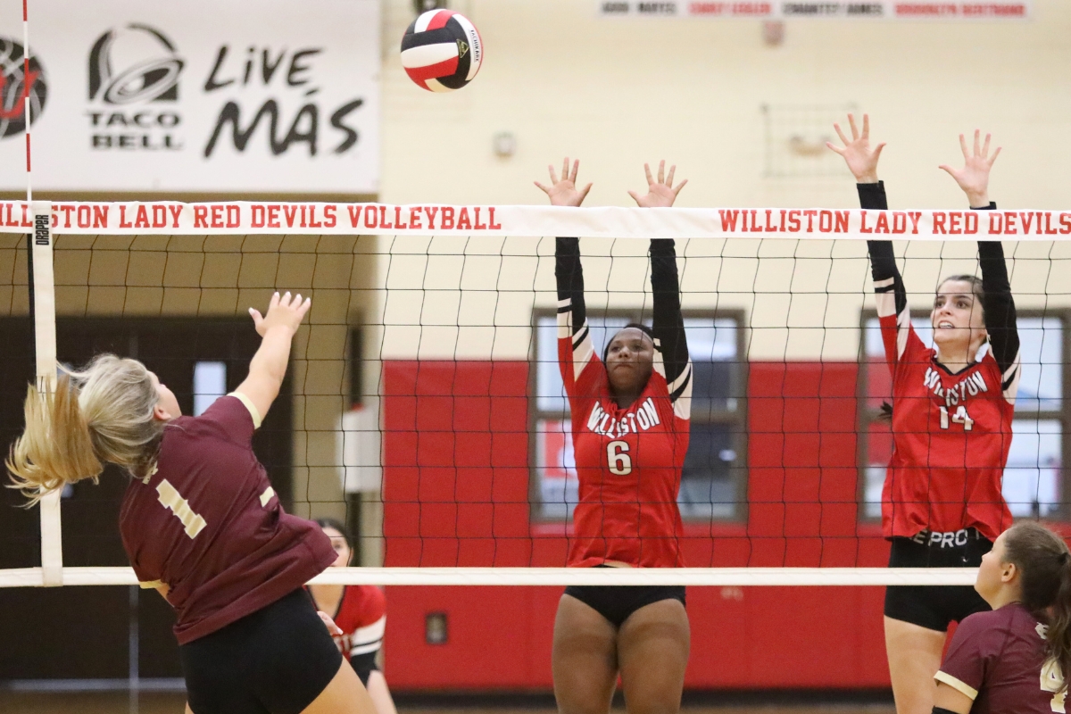 Oak Hall's Haley Janes (1) with a hit against Williston's Nevaeh Hayes (6) and Ryleigh Hiers (14) on Tuesday.