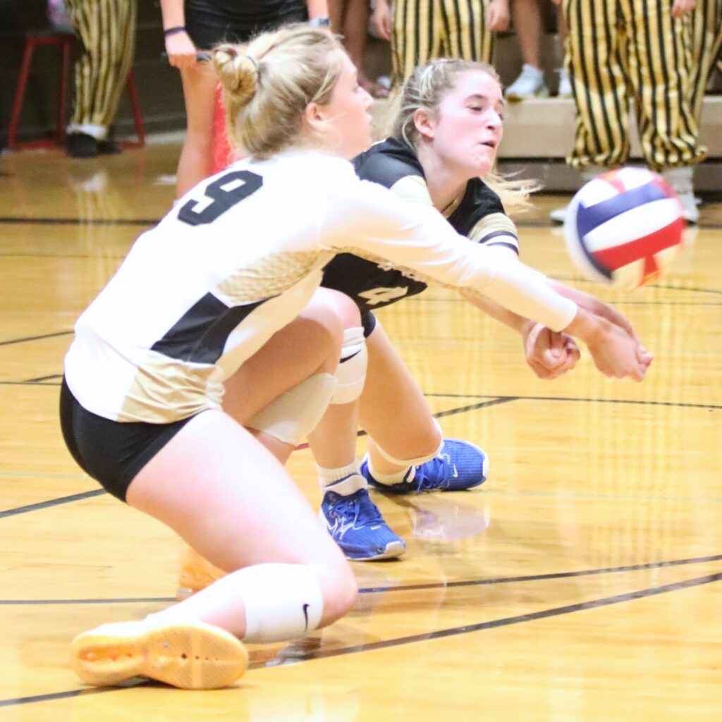 Buchholz's Maggie Whisler (left) and Hailey McLaughlin go for a dig against Gainesville on Thursday.