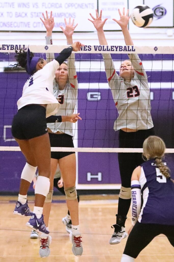 Gainesville's Meme Davis hit a hit against Santa Fe's Bryli Kuhn (3) and Alexis Rhoden (23) on Wednesday.