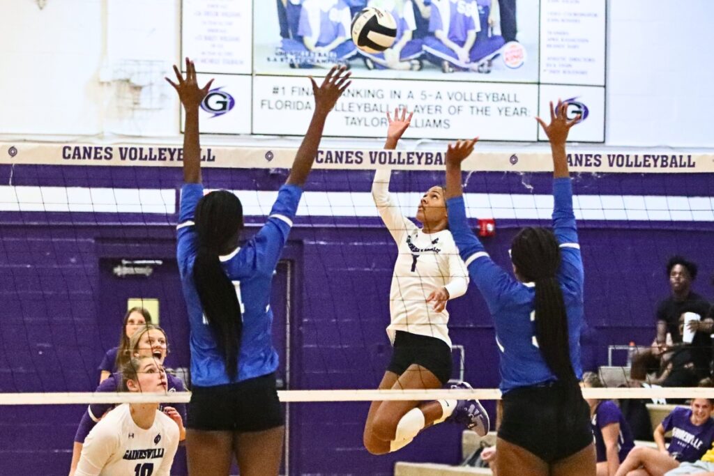 Gainesville's Meme Davis with a hit against P.K. Yonge's Jorryn Dye ( 14) and Xyiah Moore (3) on Monday.