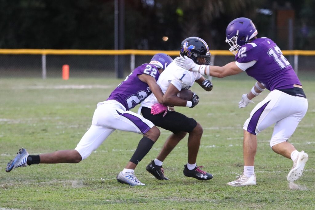 Gainesville's P.J. Williams (22) and Jeremy Figueroa (12) combine for a tackle on a Menendez punt return on Friday.