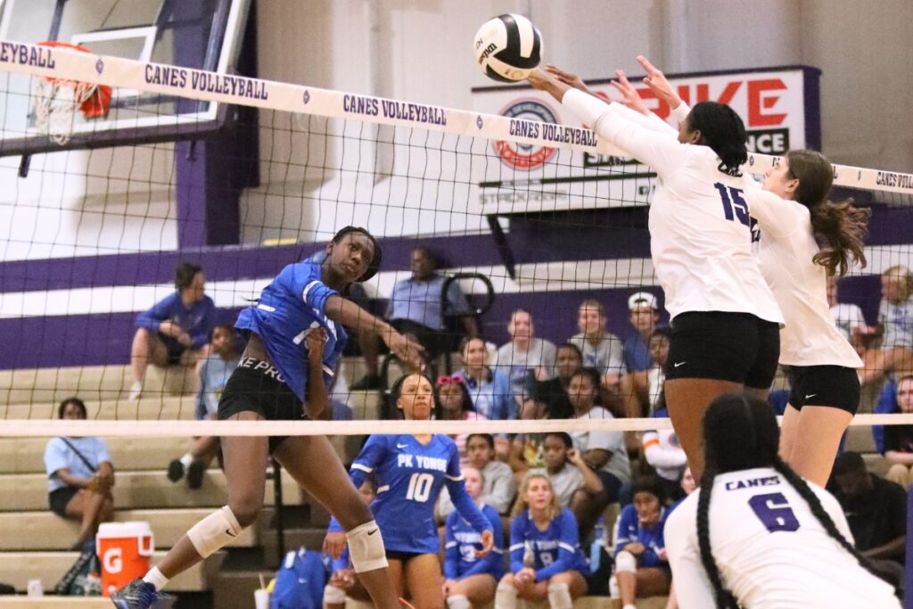 P.K. Yonge's Jorryn Dye with hit against Gainesville's Nicole Ellis (15) and Chloe Petrik (4) on Monday.