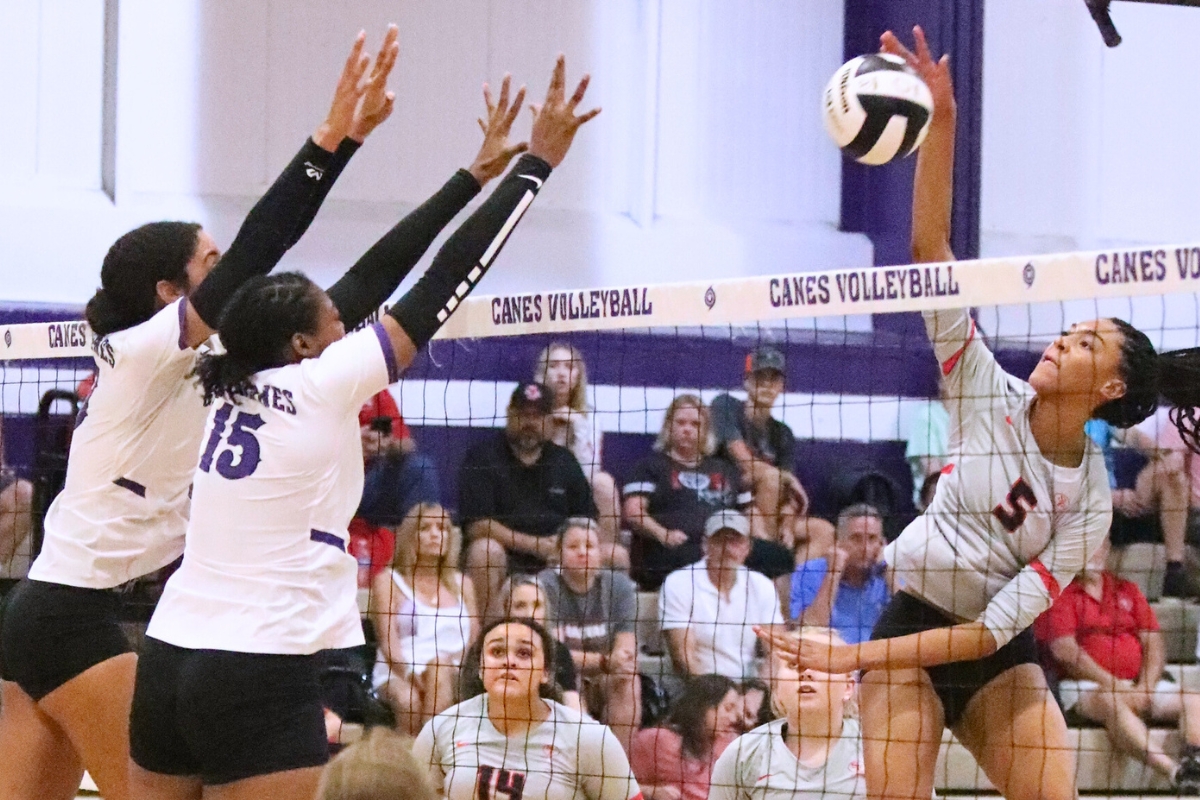 Santa Fe's Joselynn Sanjurjo (right) with a hit against Gainesville's Brooklyn Tealer and Nicole Ellis on Wednesday.
