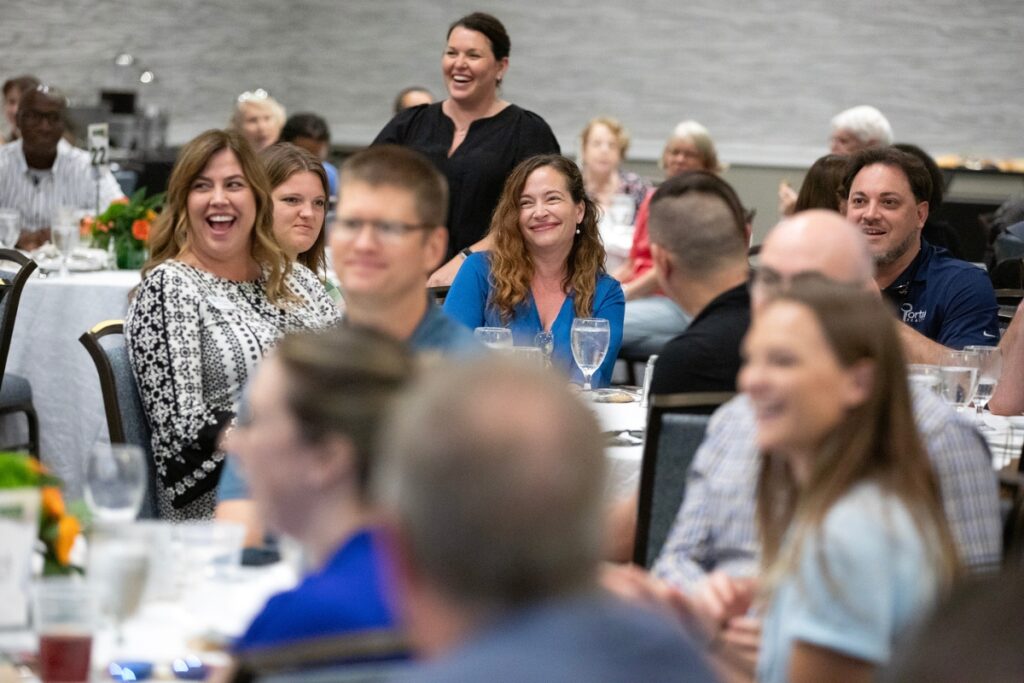 Teresa Callen, in blue blouse, smiles after her winning bid of $3,200 secured two VIP tickets to the Oct. 28 Florida-Georgia football game as well as a beach hotel stay in the Jacksonville area.
