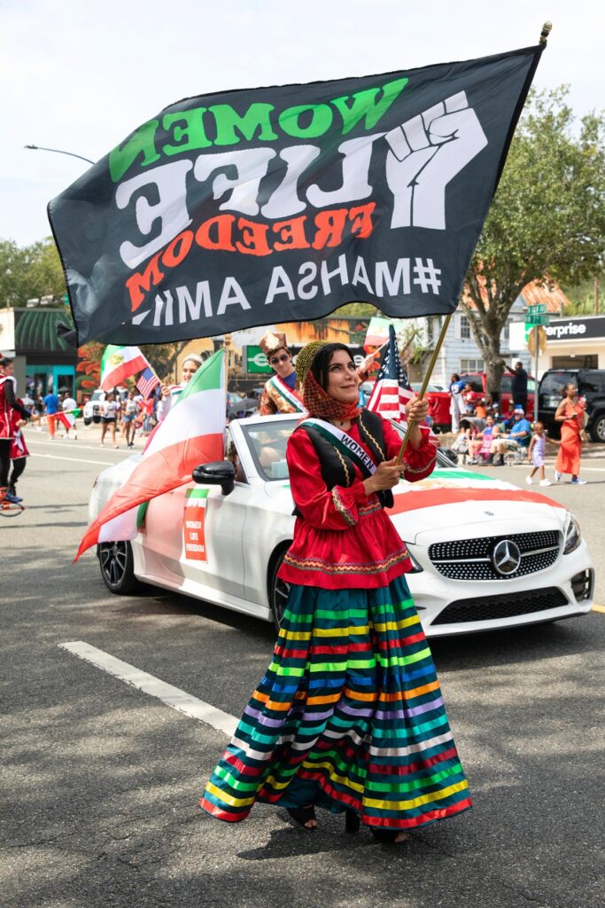 A Woman Life Freedom lady walking in the UF Homecoming Parade on Friday.