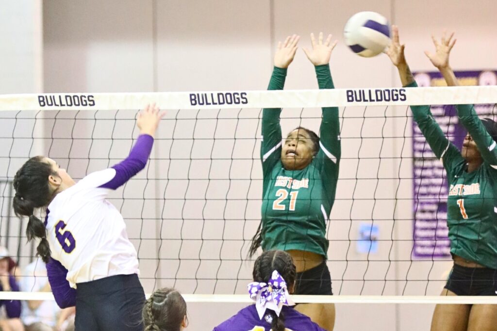 Bell's Mae Collet with a hit against Eastside's Kenadee Johnson (21) and Arielle Livingston (1) on Tuesday.