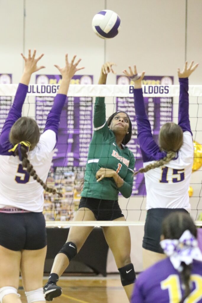 Eastside's Arielle Livingston with a hit against Bell's Jodi Waddle (5) and Dacy Graham (15) on Tuesday.