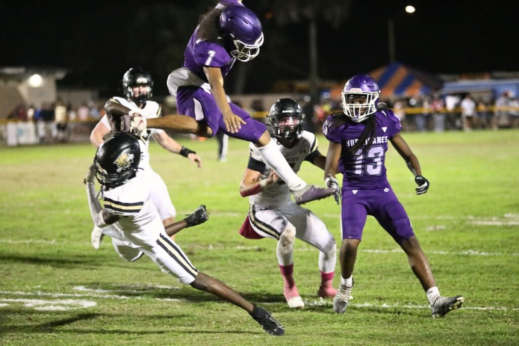 Gainesville's Kane Smith hurdles a Buchholz defender during a quarterback scramble on Thursday.
