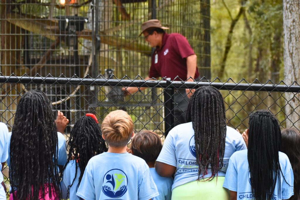 Keith Nelson, Camp Kulaqua's wildlife sanctuary director, tells Deeper Purpose students about a gibbon.