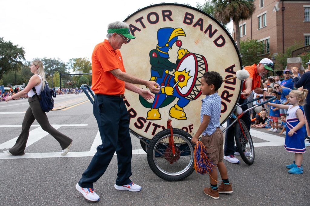 Kids beating the Gator Band drum at the UF Homecoming Parade on Friday.
