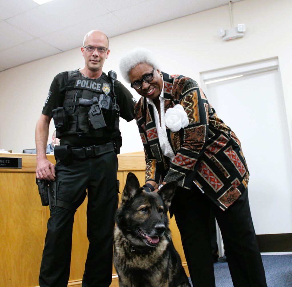 Mayor Gloria James, right, and Officer Tony Pekala, left, celebrate Cesar's retirement at Thursday's meeting.