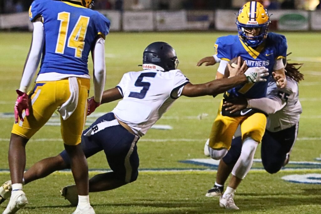 P.K. Yonge's Devin Johnson (5) and Jovani Lopez (55) tackle Newberry's Keil McGriff on Friday.