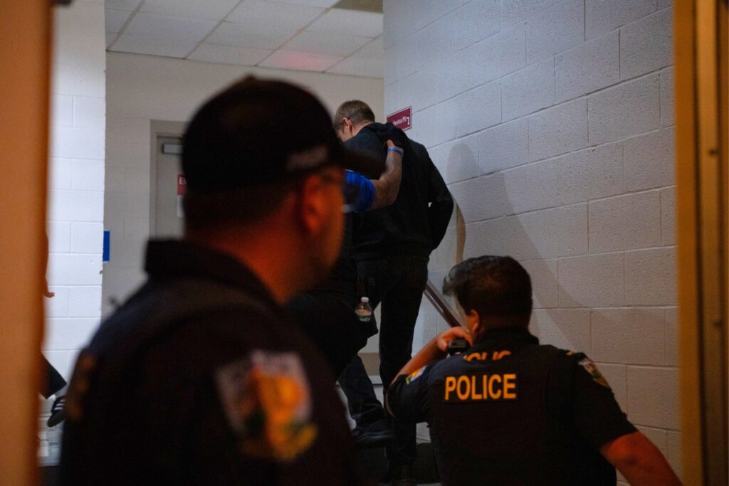 Protester being escorted out of the Phillips Center auditorium by police.