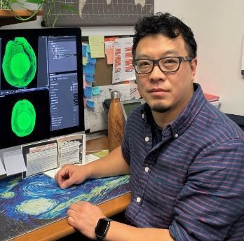 Tie Liu sits in front of a computer.