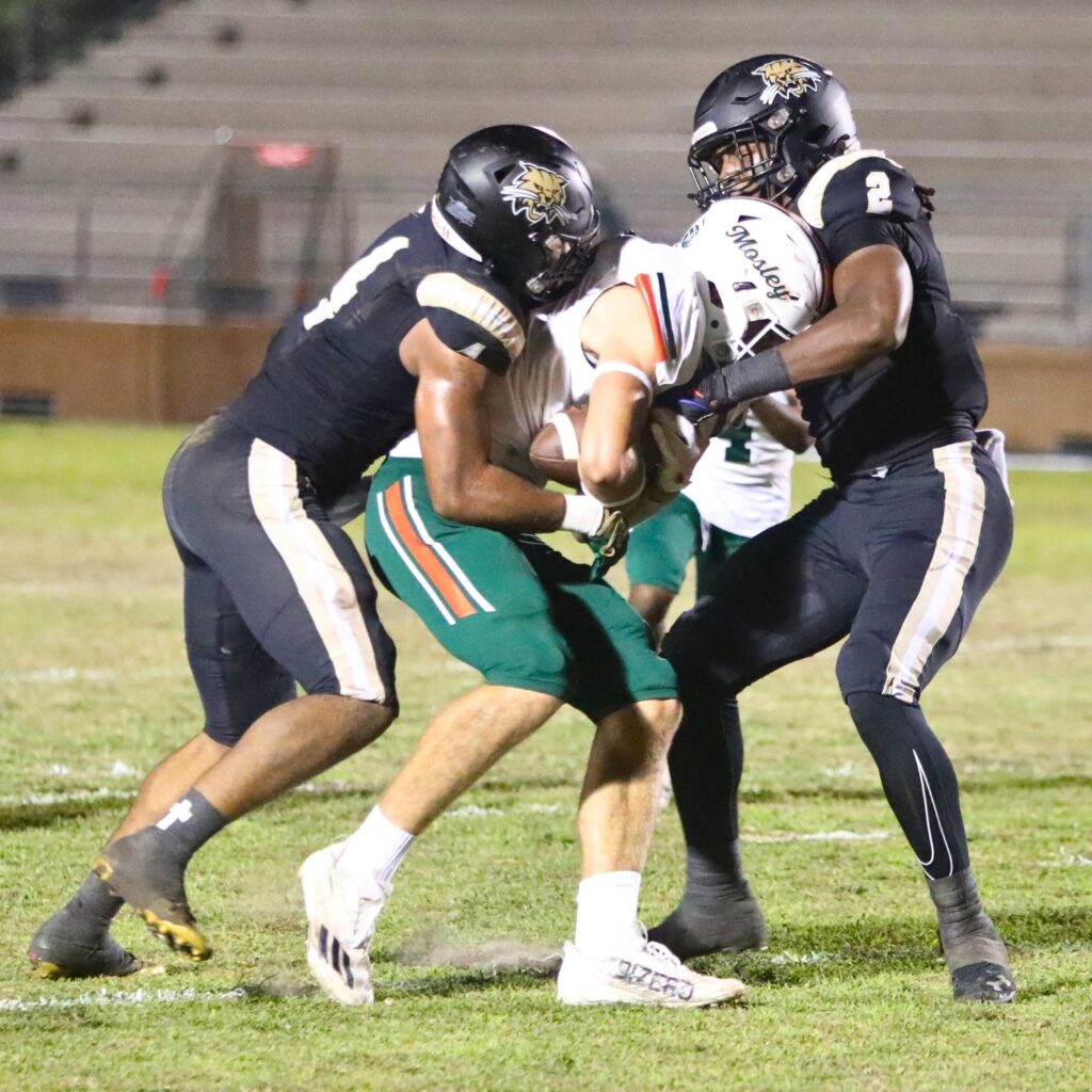 Buchholz's R.J. Livingston (4) and Myles Graham (2) with a second quarter tackle against Mosley on Thursday.